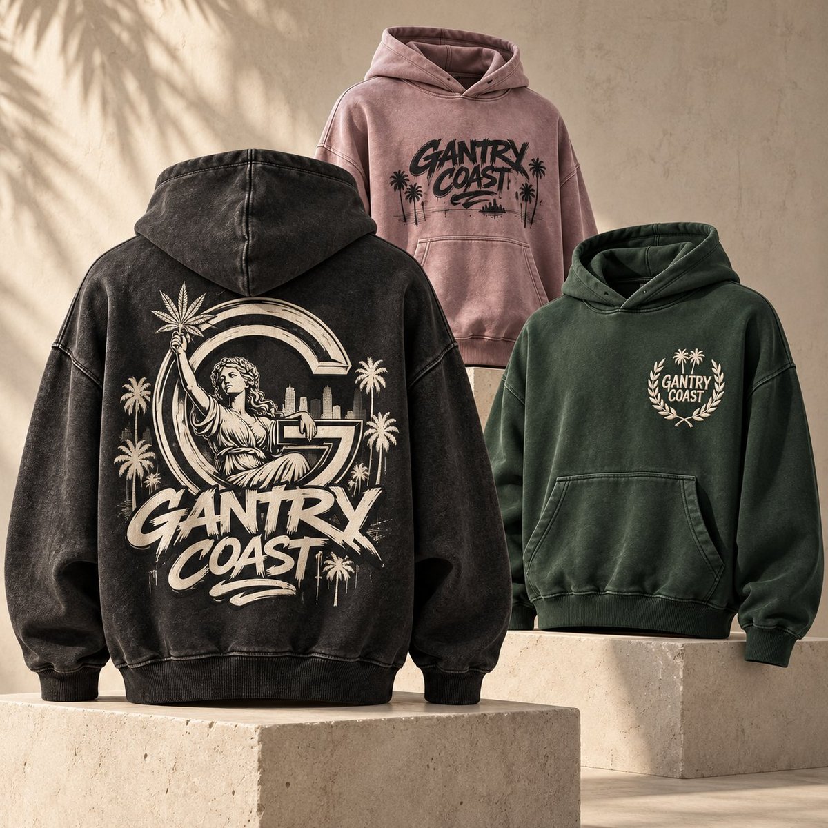 Three Gantry Coast branded hoodies displayed: black with back graphic, mauve with front logo, and forest green with wreath design